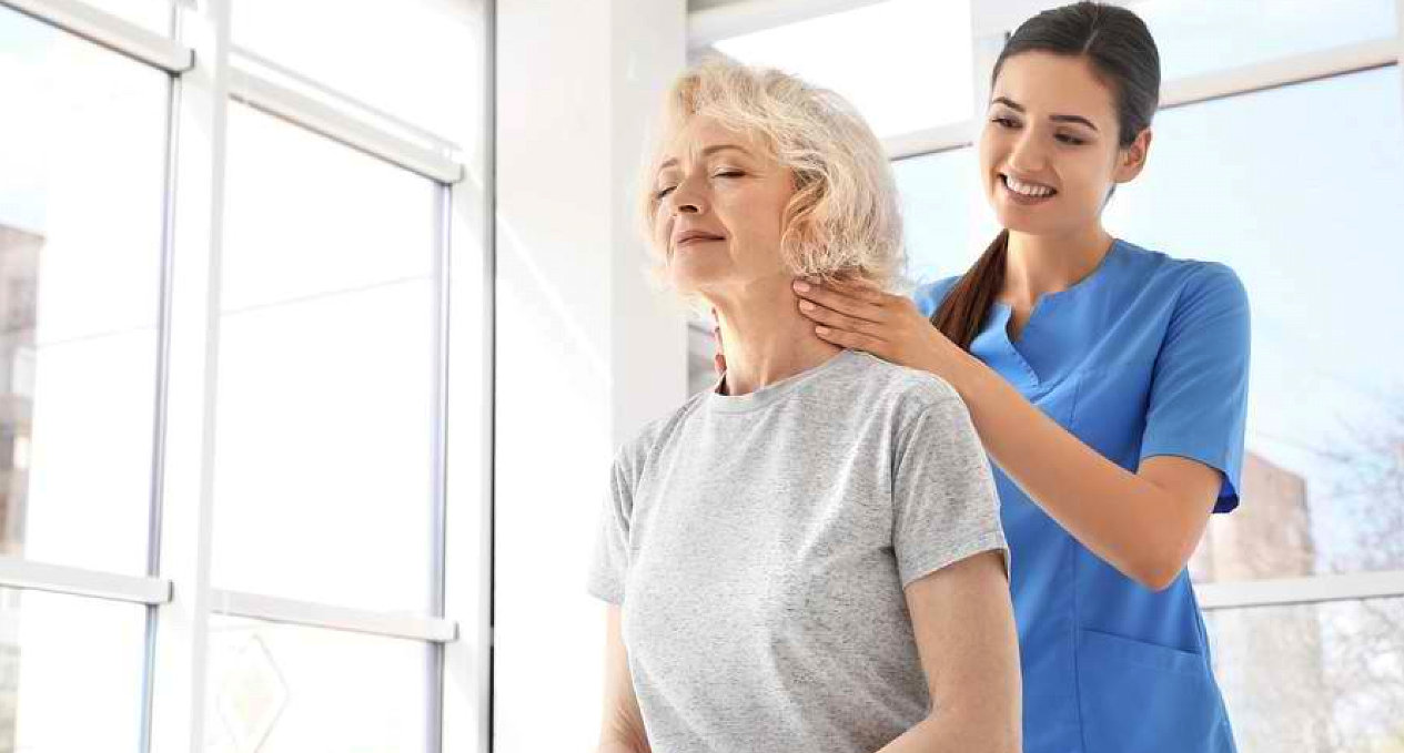 Therapist massaging an older woman's shoulder